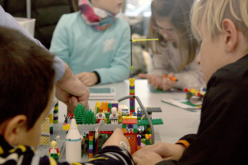 Un grupo de participantes Bebot Kids trabaja sobre su base lunar de Lego 