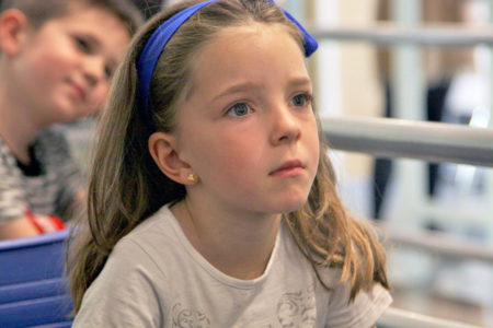 Una niña atiende a las explicaciones de la investigadora en el taller de Ciencia entre Fogones 